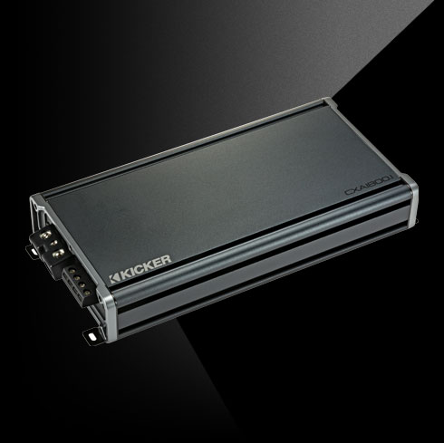 Angled top view of KICKER CXA1800.1 car amplifier showing compact chassis and terminal connections.