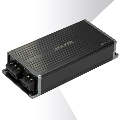 Angled view of KICKER KEY500.1 car amplifier showing ribbed black casing and side terminal connectors.