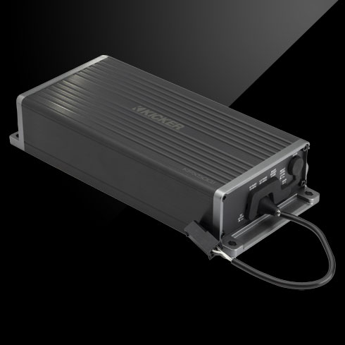 Angled view of weather-resistant KICKER KPX amplifier with ribbed casing and connected cable.